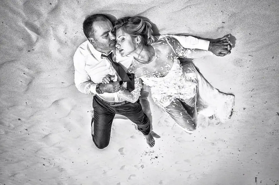 idejas kāzu gadadienai. kāzu jaunlaulātie pludmales smiltīs